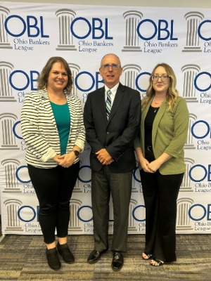 picture of two women and one man standing before a backdrop that says "Ohio Bankers League"